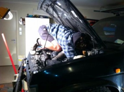 under the hood attempting to reach gearbox bolts.